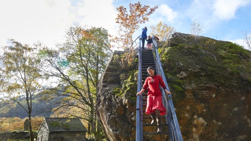 Visitors descending the steel steps from the Bowder Stone, Borrowdale, Lake District